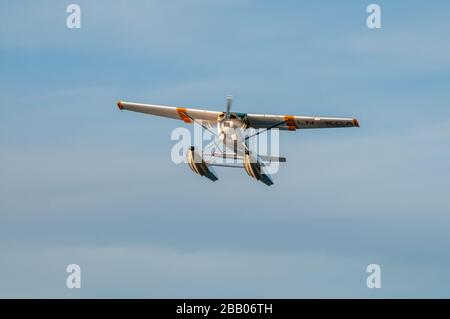 Ein gelb-weißes Wasserflugzeug Cessna 172 Skyhawk, das zwischen Inseln im Archipel Kragerø an der Südküste Norwegens abflog. Stockfoto