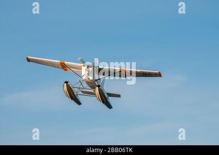 Ein gelb-weißes Wasserflugzeug Cessna 172 Skyhawk, das zwischen Inseln im Archipel Kragerø an der Südküste Norwegens abflog. Stockfoto