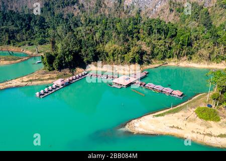 Luftaufnahme eines schwimmenden Holzsparren auf einem riesigen, von Dschungel umgebenen See (Cheow LAN Lake, Khao Sok, Thailand) Stockfoto