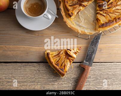 Hausgebackene apfelkuchen auf einem Holztisch mit einer Tasse Kaffee auf der Seite. Draufsicht. Stockfoto