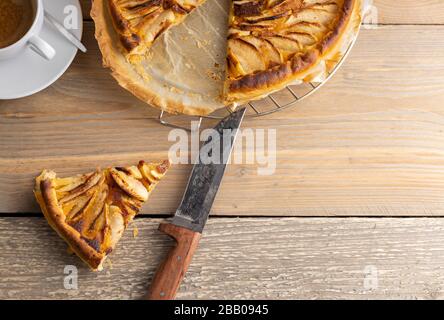 Hausgebackene apfelkuchen auf einem Holztisch mit einer Tasse Kaffee auf der Seite. Draufsicht. Stockfoto