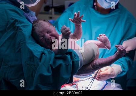 Eine Nahaufnahme eines Arztes, der ein neugeborenes Baby hält. Stockfoto