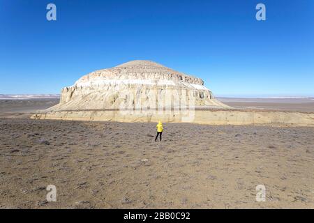 Frau, die in der Wüste vor Löwenfelsen steht - Felsformationen in der Wüste Kaspische Depression, Aktau, Mangystau, Kasachstan Stockfoto