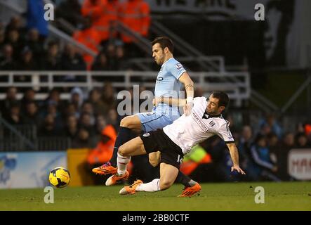 Der Alvaro Negredo von Manchester City (links) und der Giorgos Karagounis von Fulham (rechts) kämpfen um den Ball Stockfoto