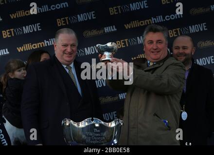 William Hill's Director of Retail James Henderson mit dem siegreichen Trainer Paul Nicholls, nachdem er den William Hill King George VI Steeple Chase gewonnen hatte Stockfoto