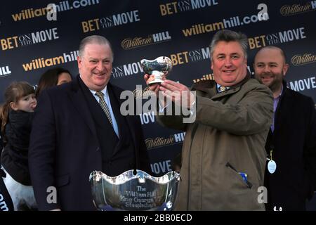 William Hill Direktor von Retail James Henderson (links) mit Trainer Paul Nicholls nach dem Sieg mit Silviniaco Conti im William Hill King George VI Steeple Chase Stockfoto