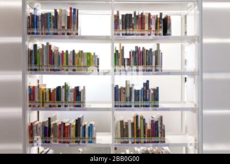 Bücher im Bücherregal im Bibliotheksraum, abstrakte Unschärfe des fokussierten Hintergrunds. Stockfoto