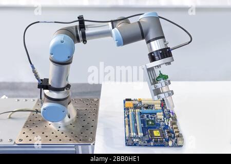 Industrieroboter, der werkseitig einen Computerchip an der Produktionslinie installiert, Regler des Roboterarms. Stockfoto