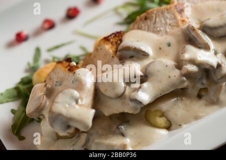 Huhn auf geriebenem Gnocchi in Sahnesauce aus Pilzen und Räucherkäse auf dem Tisch Stockfoto