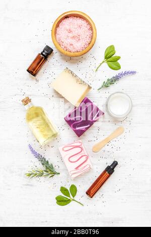 Draufsicht auf organische Seifen und Kosmetik mit Lavendel, Kräutern, chia und ätherischen Ölen. Weißer rusrischer Hintergrund. Stockfoto