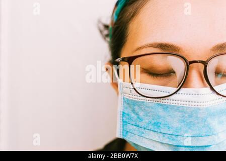 Coronavirus Thema. Asiatische Frau mit Brille, die eine Maske trägt, um sich vor Infizierung zu schützen Stockfoto