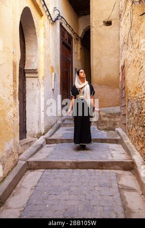 Fes, Marokko: Junge verschleierte Frau, die in der Medina spaziert Stockfoto