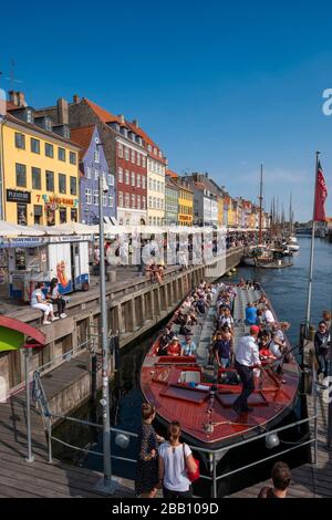 Menschen, die von einem Ausflugsboot am Kai am Nyhavn Kanal in Kopenhagen, Dänemark, Europa, aussteigen Stockfoto