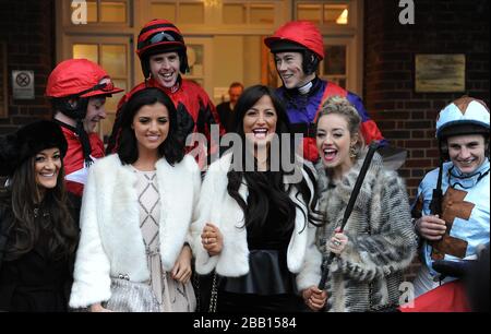 Chantelle Houghton (Center), Lucy Mecklenburgh (2nd Left) und Kelsey Hardwick (2nd Right) spielen während des ersten Tages des Tingle Creek Christmas Festivals auf der Sandown Racecourse mit einer Jockey's Whip Stockfoto