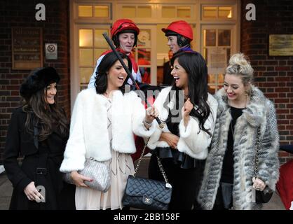 Chantelle Houghton (2. Rechts), Lucy Mecklenburgh (2. Links) und Kelsey Hardwick (rechts) spielen während des ersten Tages des Tingle Creek Christmas Festival auf der Sandown Racecourse mit einer Jockey's Whip Stockfoto