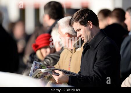 Ein Rennbocks überprüft das Formular in der Racing Post während des Tingle Creek Christmas Festival auf der Sandown Racecourse Stockfoto