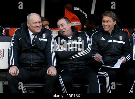 Fulham-Manager Martin Jol (links) spricht mit seinem Cheftrainer Rene Meulensteen (Mitte) und Michael Lindeman im Dugout Stockfoto