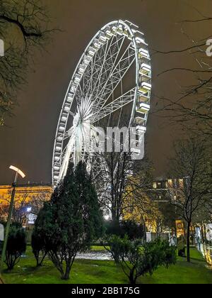 Nächtliche Sicht auf ein Riesenrad mit Flutlicht in Budapest, Ungarn. Eine fantastische Touristenattraktion im Herzen der Stadt. Stockfoto