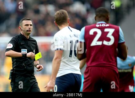 Schiedsrichter Michael Oliver zeigt eine gelbe Karte für Issa Diop von West Ham United (rechts) Stockfoto