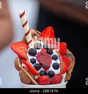 Tasse mit köstlicher süßer Blasengewelle auf dunklem Hintergrund Stockfoto