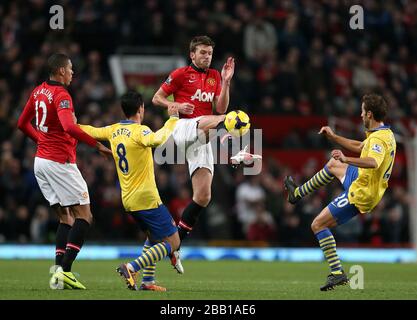 Michael Carrick (Center) von Manchester United übernimmt Mathieu Flamini (rechts) und Mikel Arteta (links) von Arsenal Stockfoto