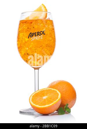 LONDON, Großbritannien - 01. APRIL 2020: Aperol Spritz Sommercocktail mit Eis und Orangenscheibe in Weinglas auf weißem Hintergrund mit frischen Orangen und Minze lea Stockfoto