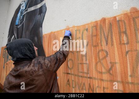 Der Graffiti-Künstler Olivier Roubieu wendet den letzten Schliff auf sein Wandbild an, das Sandown's Tingle Creek Christmas Festival während des Gentleman's Day wirbt Stockfoto