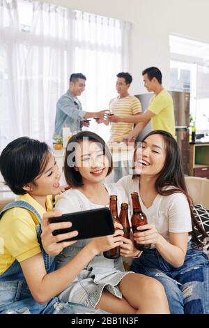 Ziemlich lächelnde weibliche Freunde, die Gruppe selfie auf der Hausparty nehmen Stockfoto