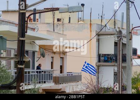 ALEXANDROUPOLI, GRIECHENLAND - 24. März 2020 - EIN Mann auf sitzt auf einem Wohnbalkon in Alexandroupoli, Griechenland, nachdem die griechische Regierung eine strikte Sperre verhängt hatte Stockfoto