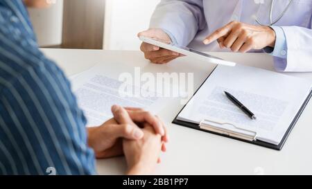 Technologie in Medizin und Gesundheitswesen, Beratung Von Ärzten Diskussion von Aufzeichnungen mit dem Patienten durch Verwendung digitaler Tablette in der Arztpraxis. Stockfoto