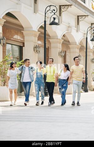 Fröhliche asiatische Jugendliche genießen an sonnigen Tagen Spaziergänge auf der Straße Stockfoto