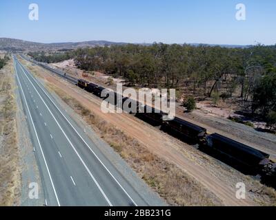Antenne mit 120 Wagen und 2 km langem Güterzug, der Kohle zu den Exportterminals von Gladstone Queensland Australia entlang der Capricorn Highw transportiert Stockfoto