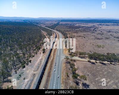 Antenne mit 120 Wagen und 2 km langem Güterzug, der Kohle zu den Exportterminals von Gladstone Queensland Australia entlang der Capricorn Highw transportiert Stockfoto