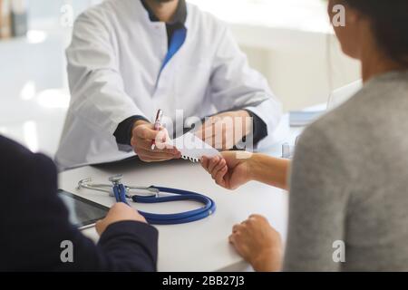 Selbstbewusster Arzt verschreibt Patienten in der Klinik. Stockfoto