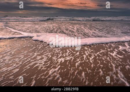 Abendlicht über eine Flut am Fistral Beach in Newquay in Cornwall. Stockfoto