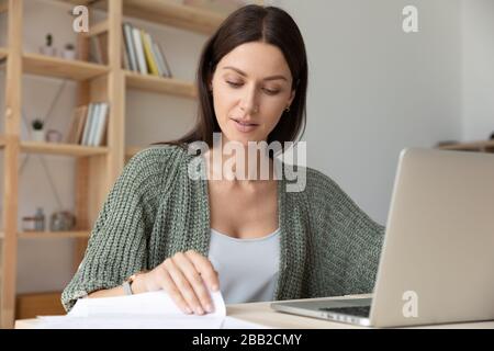 Fokussierte weibliche Angestellte beschäftigt sich mit der Arbeit am Laptop Stockfoto