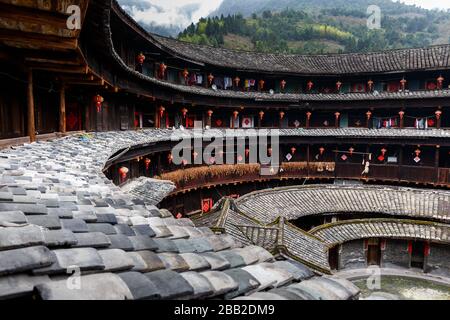 Blick vom Balkon eines Fujian Tolou - mit Blick auf die Holzdachziegel und mehrere Etagen. Traditionelle Rundhäuser der Hakka. Stockfoto