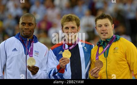 Der britische Jason Kenny (Center) feiert mit seiner Goldmedaille neben dem Silbermedaillengewinner Gregory Bauge (links) und dem Bronzemedaillengewinner Australiens Shane Perkins nach dem Sprint Finale der Männer Stockfoto