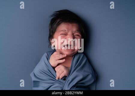 Neugeborenes weinendes Baby. Neugeborenes Kind müde und hungrig, nachdem es posiert hat Stockfoto