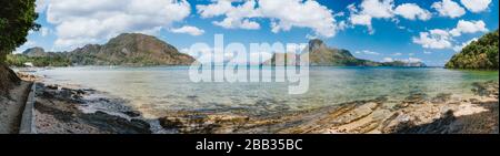Palawan, Philippinen. Panoramabild der Bucht von El Nido am sonnigen Sommertag. Malerische Küstenlinie, tropischer Strand, Meer und Wolkenlandschaft Stockfoto