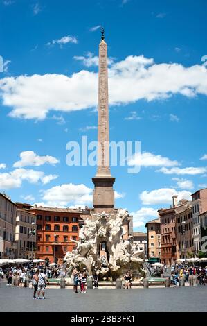 Die Touristen schleudern sich um den Brunnen der vier Flüsse (Fontana dei Quattro Fiumi) und den Obelisk von Domitian auf der Piazza Navona, Rom, Italien Stockfoto