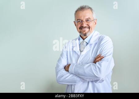 Fröhliche reife Arzt posing und lächelnd an Kamera, Gesundheitswesen und Medizin. Stockfoto