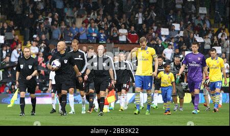 Die Spieler von Fulham und Arsenal gehen für das Spiel auf das Spielfeld Stockfoto