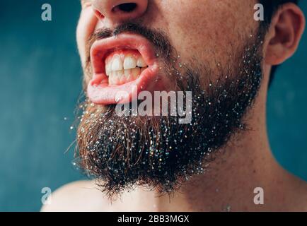 Junger Mann isoliert über Hintergrund. Schnittansicht und Nahaufnahme bärtiger männlicher Person zeigen Zähne. Gesunde gute Mund- und Zahnpflege. Nahaufnahme der Lippen und Stockfoto