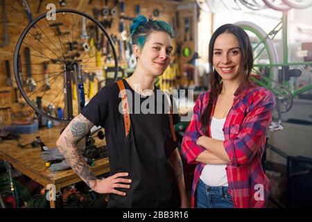 Zwei junge Frauen, die in einer Fahrradreparaturwerkstatt arbeiten Stockfoto