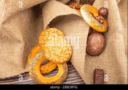 Bagels, Plätzchen, SchokoladenLebkuchen und Schokolade auf einem Stoffhintergrund mit rauer Textur. Nahaufnahme Stockfoto