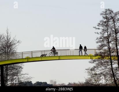 Duisburg, Deutschland. März 2020. Die Menschen laufen paarweise über eine Brücke an der Sechseenplatte. In Nordrhein-Westfalen gibt es ein Versammlungsverbot für mehr als zwei Personen unter Ausschluss von Familien, um die weitere Ausbreitung der Coronavirus-Pandemie zu verlangsamen. Kredit: Roland Weihrauch / dpa / Alamy Live News Stockfoto