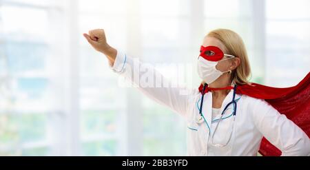 Arzt oder Krankenschwester tragen chirurgische Gesichtsmaske im superheldenkaper. Medizinisches Personal bei Ausbruch des Coronavirus. Superheldenkraft für Klinik- und Krankenhausaufenthalten Stockfoto