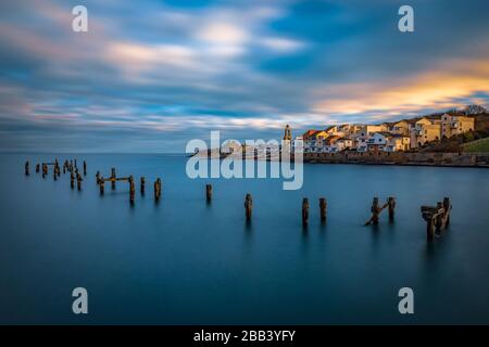 Swanage Pier bei Sonnenuntergang am Neujahrstag mit Blick auf Peveril Point Apartments. Lange Belichtung, die die Schönheit des alten Piers in Swanage unterstreicht. Stockfoto