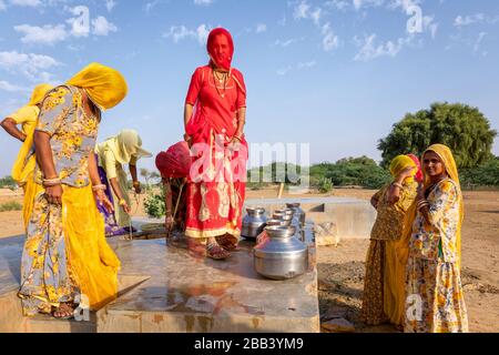 Frauen, die Wasser aus einem Brunnen der Gemeinde sammeln, Thar-Wüste, Rajasthan, Indien Stockfoto